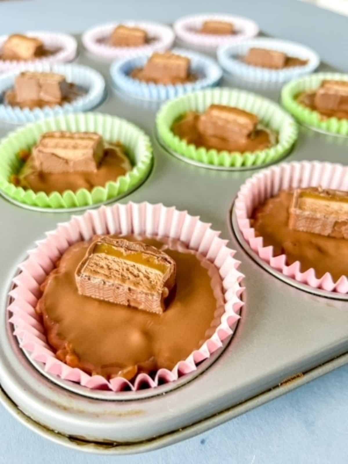 Close up of mars bar rice krispie cakes in a muffin tin.